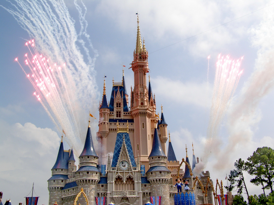 Fireworks in sky over fairy tale castle in amusement park